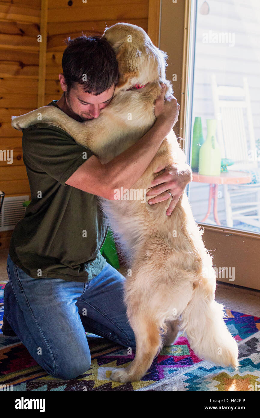 man-hugging-golden-retriever-dog-HA2PJP.jpg