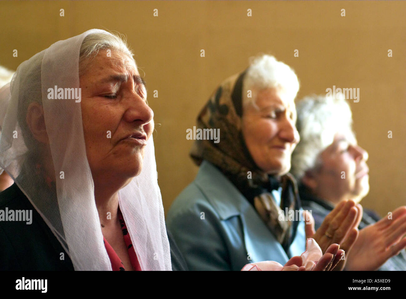 armenia-vanadzor-three-older-women-pray-in-church-with-heads-covered-A5XED9.jpg