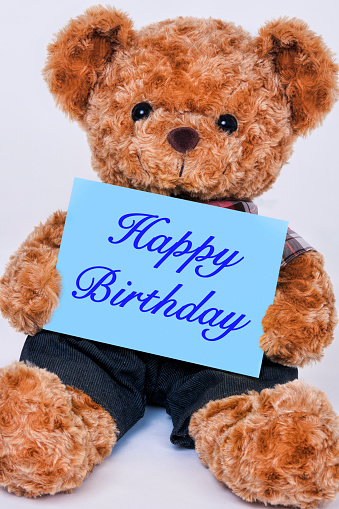teddy-bear-holding-blue-sign-saying-happy-birthday-picture-id1165441352